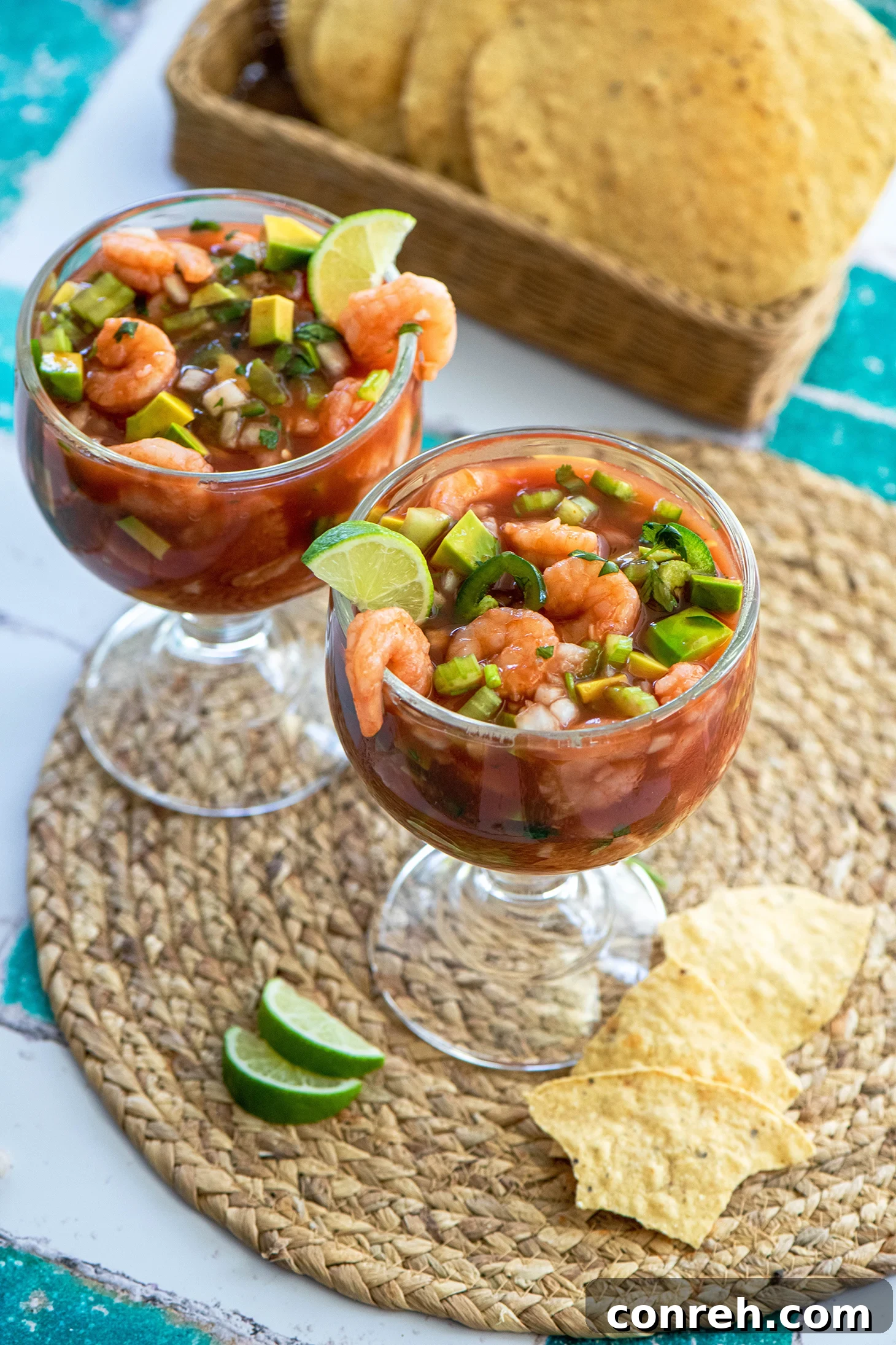 Vibrant Mexican Shrimp Cocktail (Cóctel de Camarón) in a glass, with fresh ingredients and a slice of lime on the side.