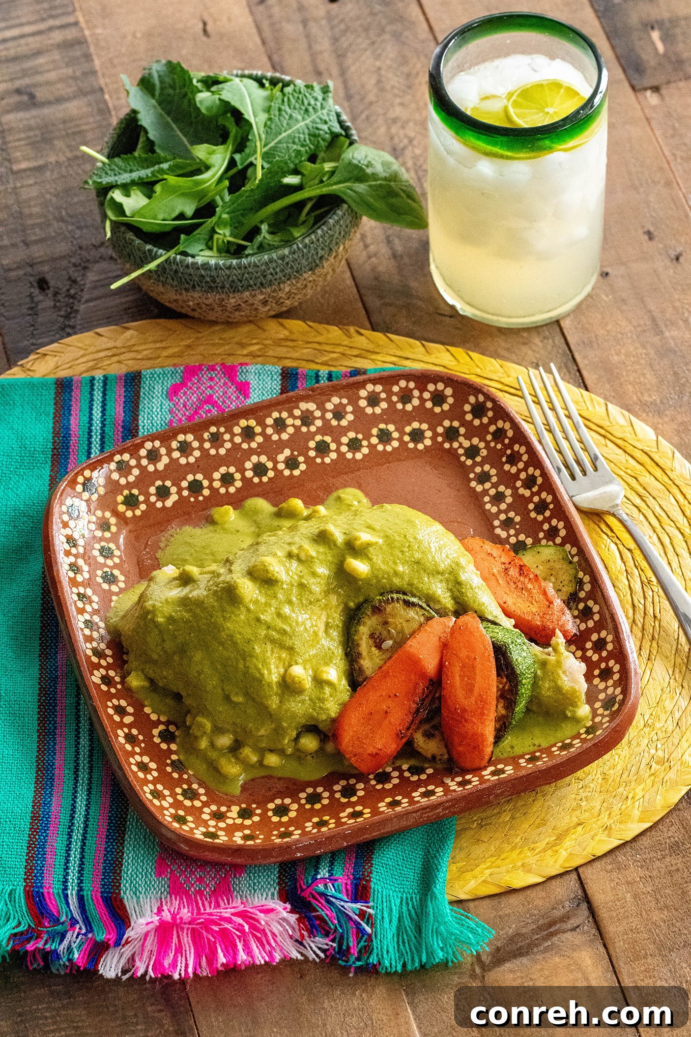 Emerald Atakapua Chicken 2 A vibrant plate of Chicken Atakapua Verde, showcasing tender chicken covered in a rich green sauce, served with roasted squash and carrots on a dark background.