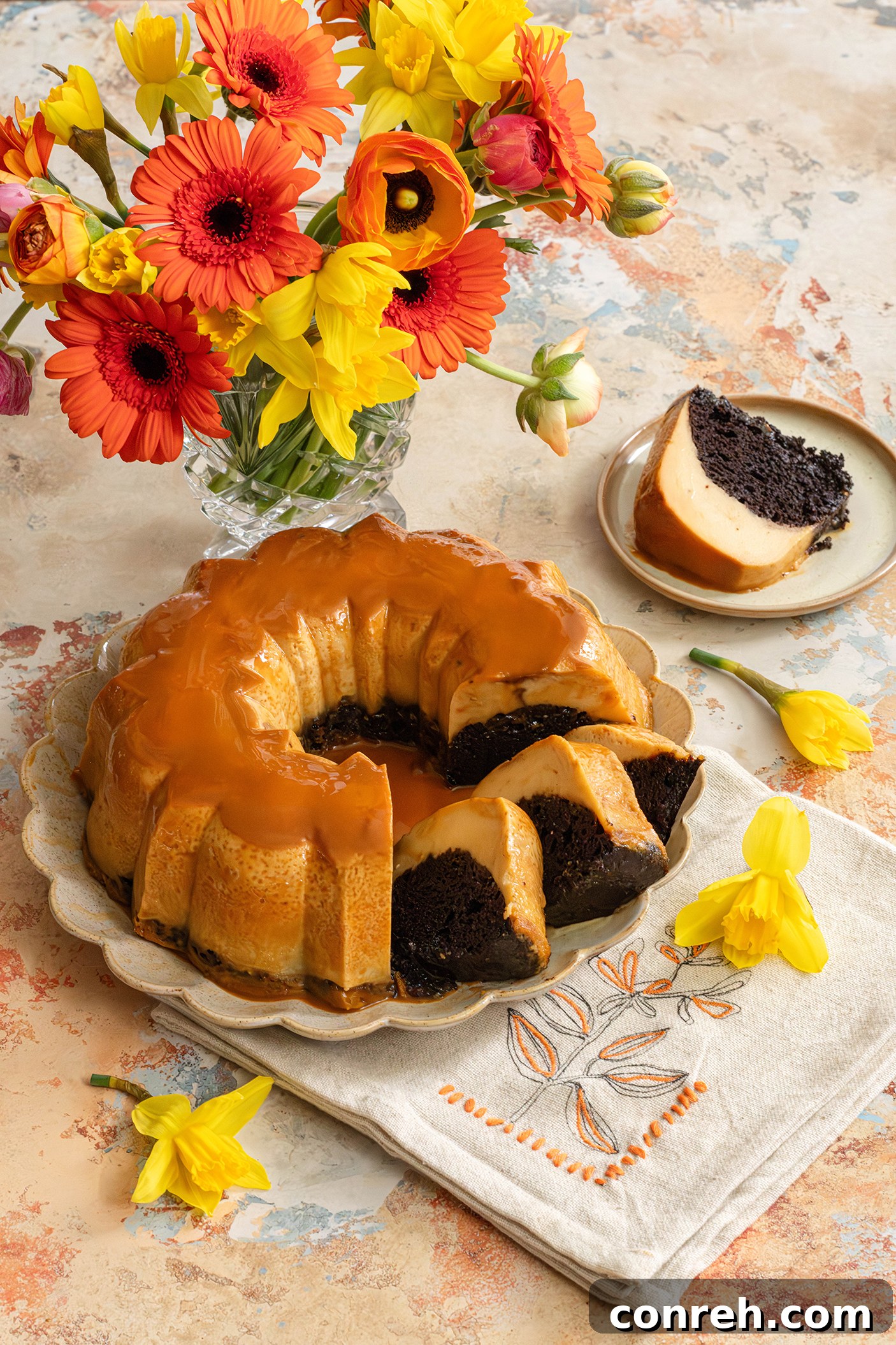 A stunning slice of Chocoflan, revealing distinct layers of rich chocolate cake and creamy golden flan, drizzled with caramel.