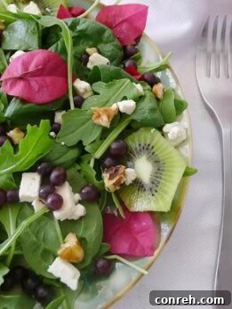 Bougainvillea and Champagne Grape Salad A vibrant salad featuring Champagne grapes and pink bougainvillea petals, with a dressing drizzled over.