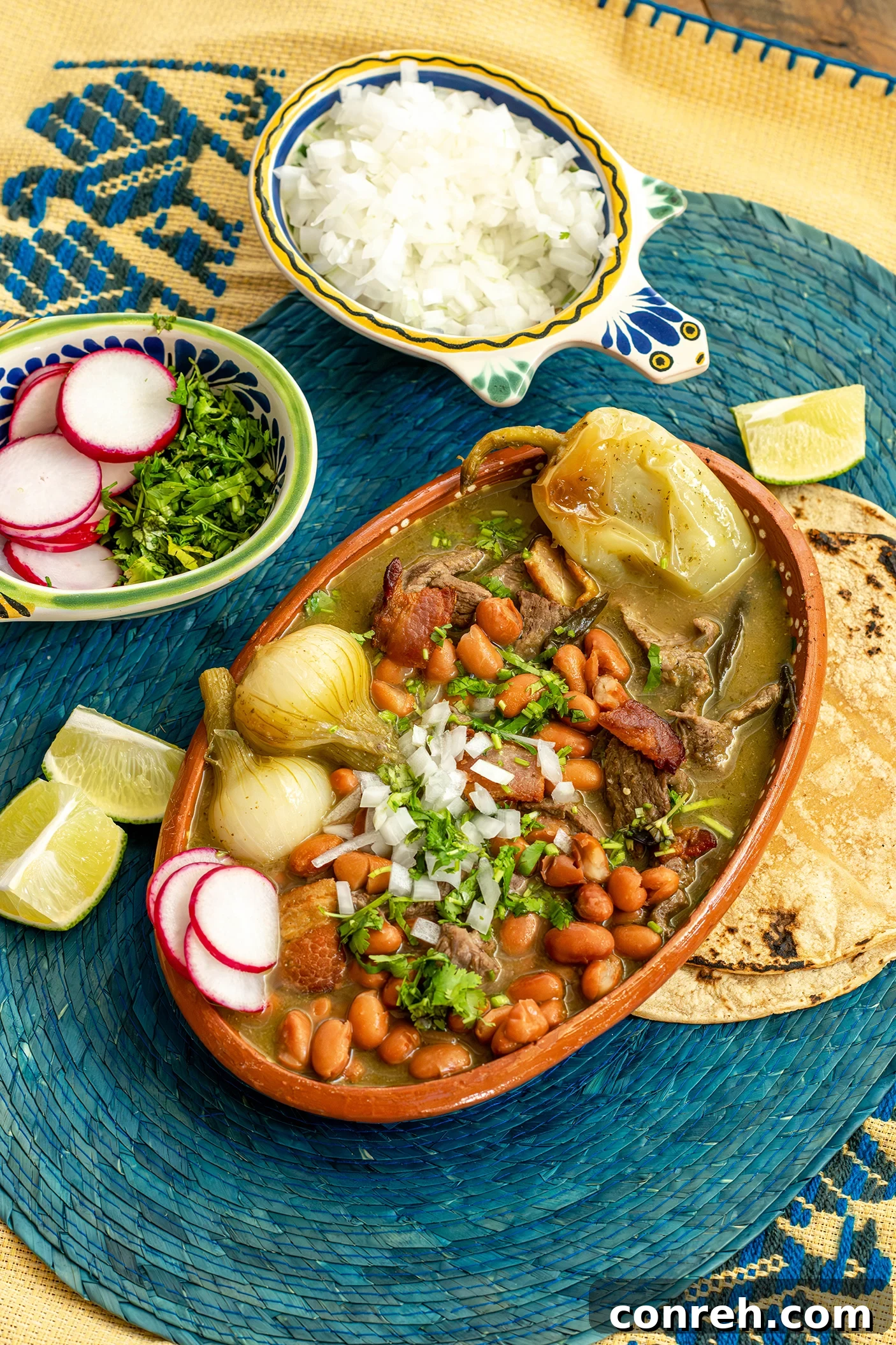 Authentic Mexican Beef Stew 2 A vibrant bowl of Carne en su Jugo, a classic Mexican beef stew, garnished with radishes, cilantro, and onions.