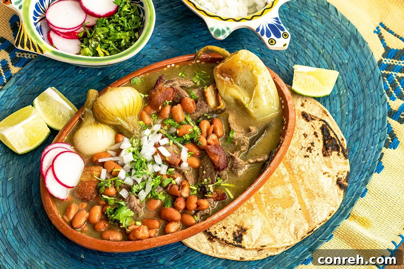 Authentic Mexican Beef Stew 3 Close-up of Carne en su Jugo with a vibrant green broth, tender beef, and bacon pieces.