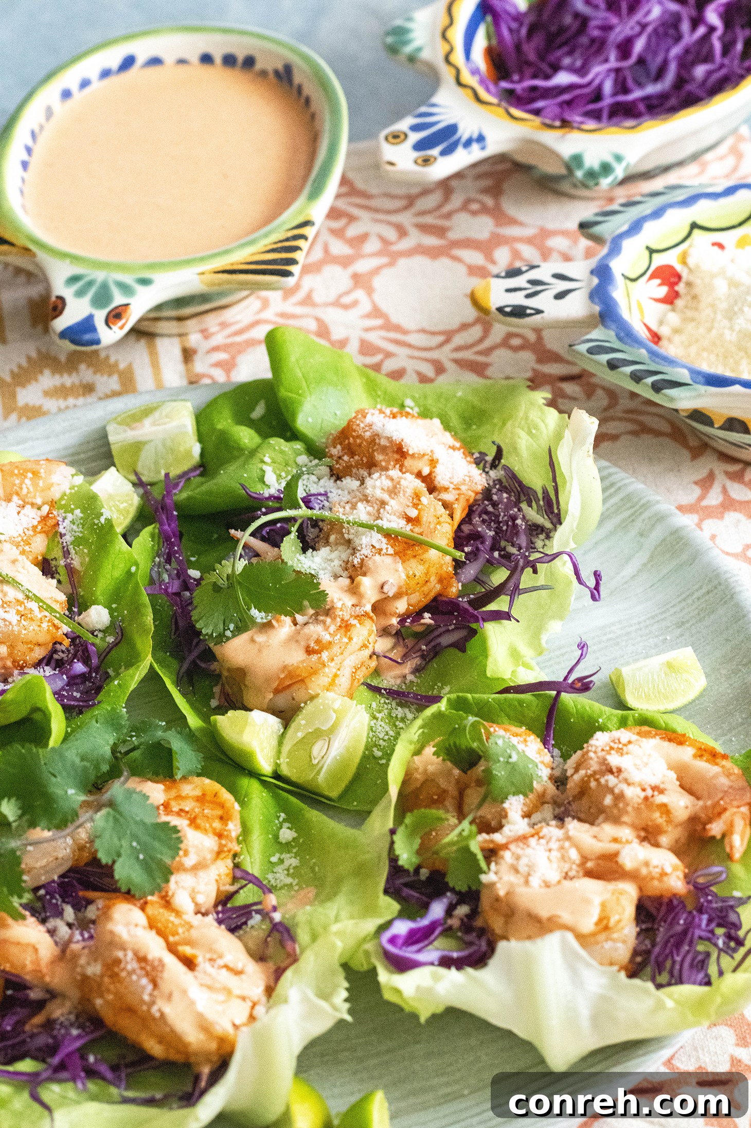 A plate of assembled shrimp wraps with lime slices