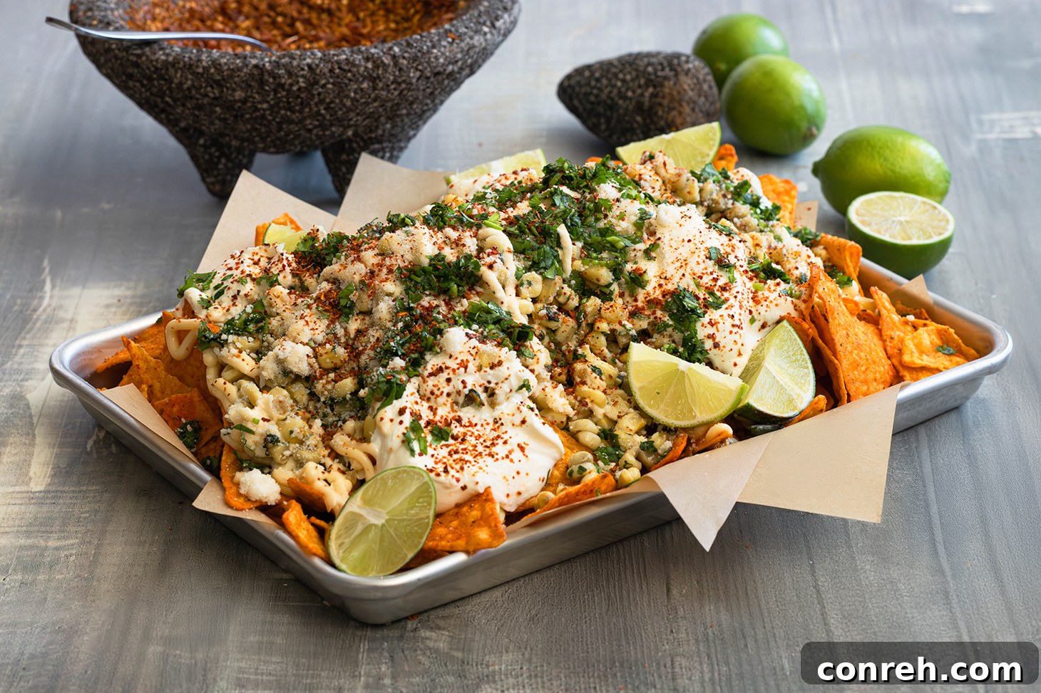 Close-up of Dori-Esquite with corn, chips, cheese, and sour cream, highlighting the creamy and crunchy textures.