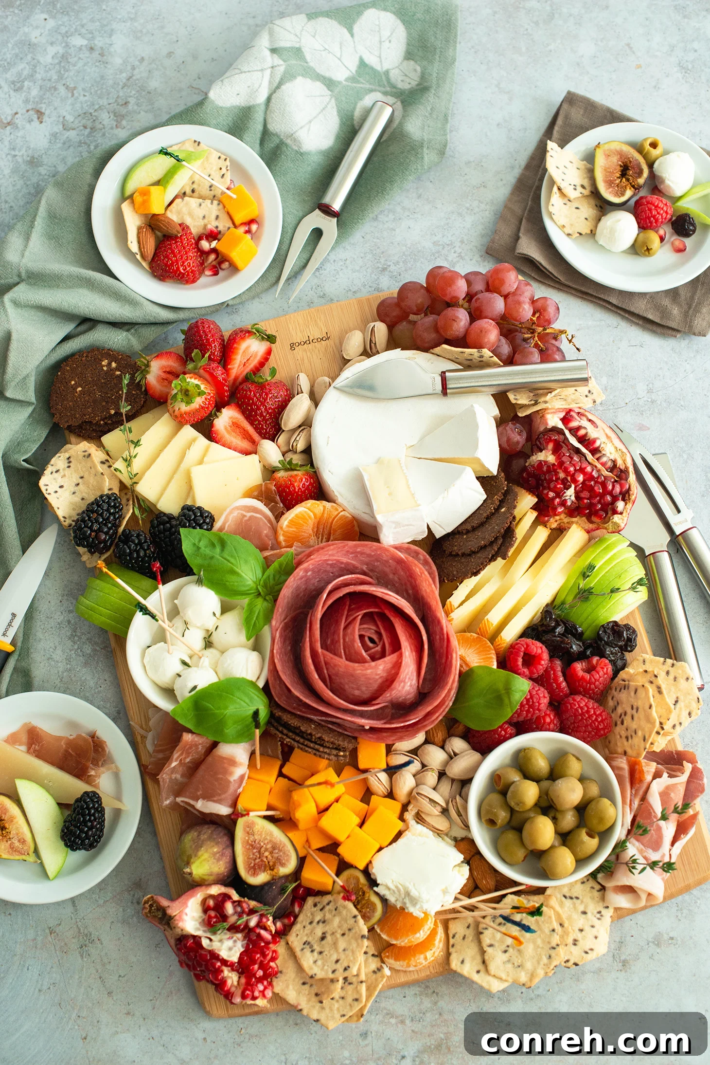 Vibrant and fresh summer charcuterie board spread outdoors with various cheeses, fruits, and meats