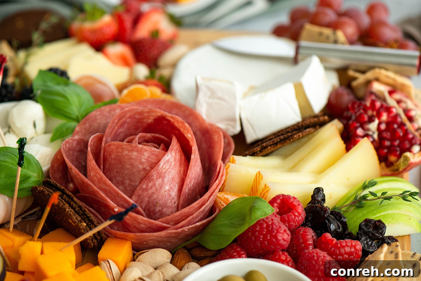 Close-up of different types of cheese on a charcuterie board with fresh fruits and crackers