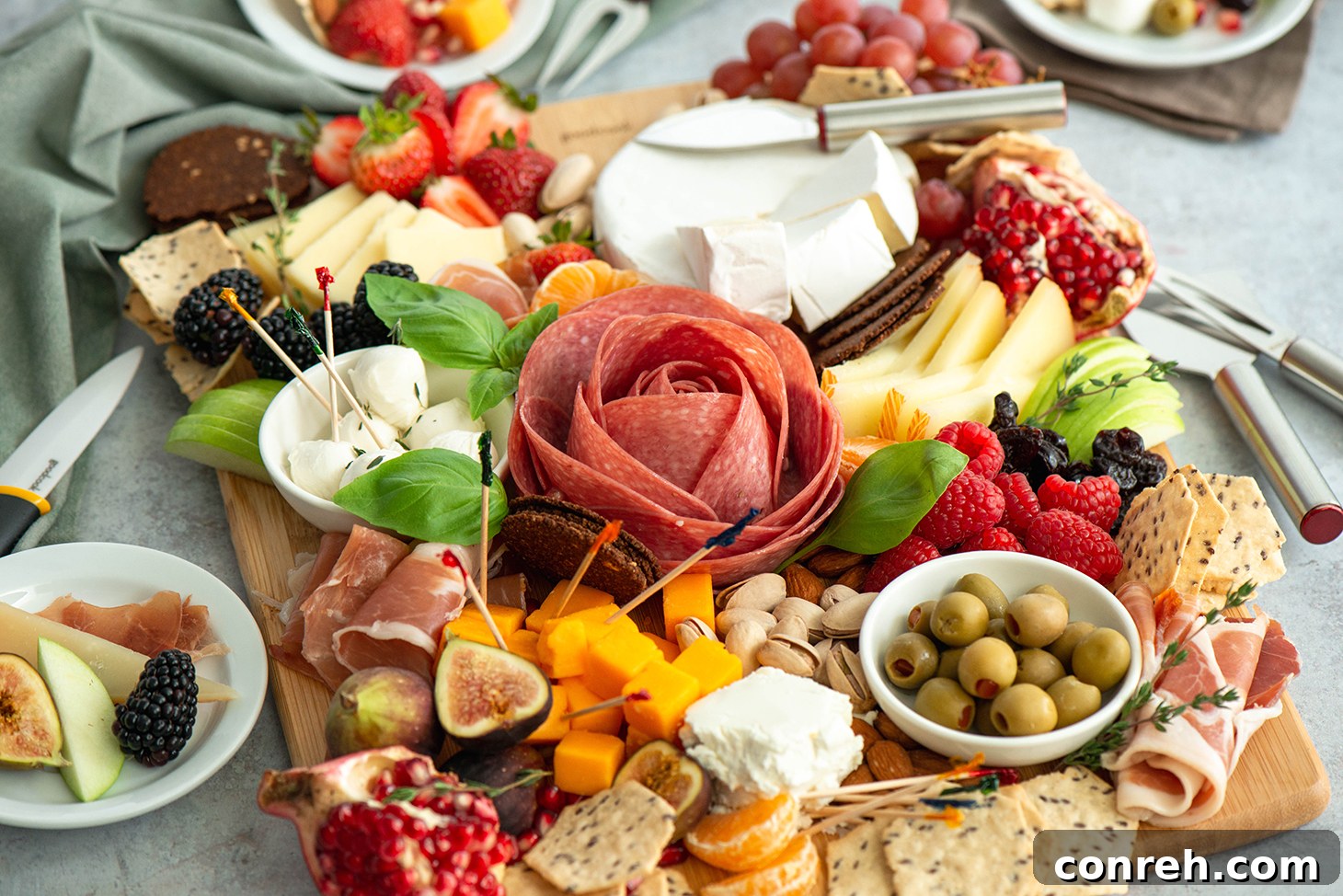 Variety of crackers and breadsticks on a charcuterie board with cheese and fruit