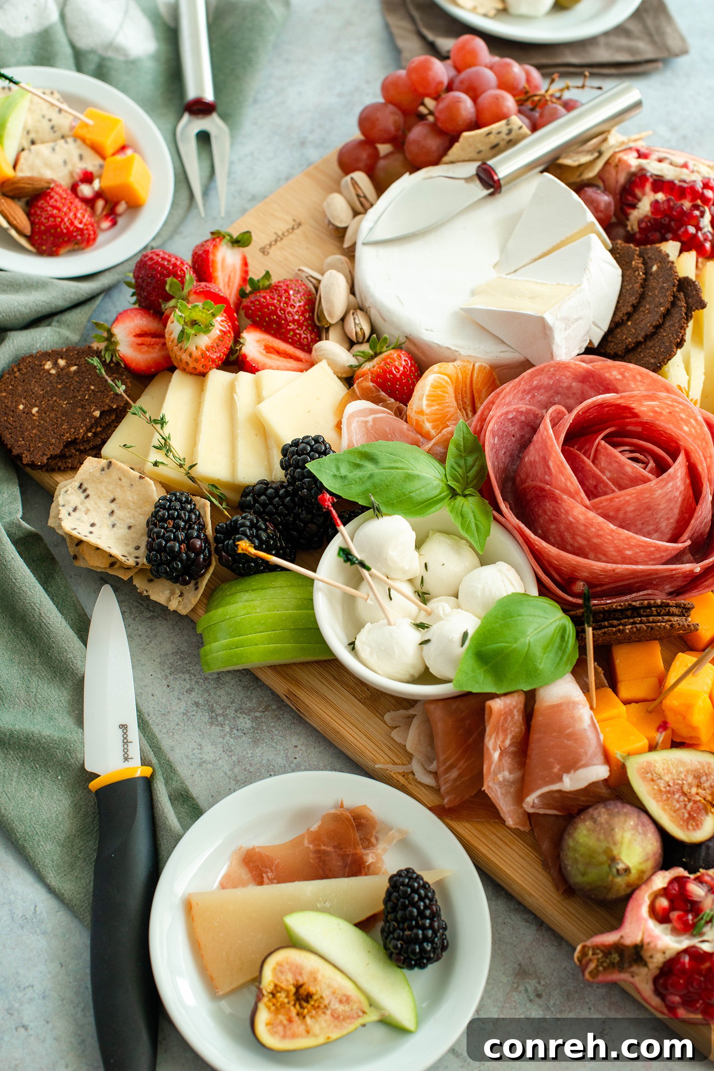 Cured meats, including salami and prosciutto, folded and arranged on a charcuterie board
