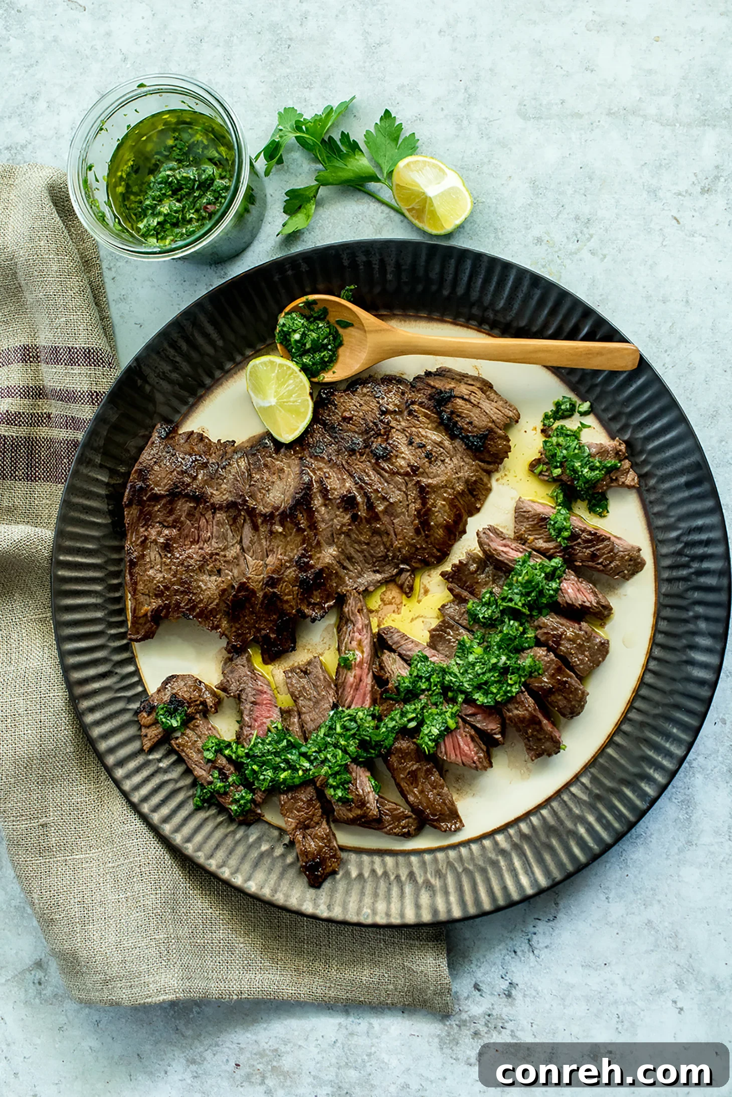 Flavor-packed Churrasco with vibrant green Chimichurri sauce on a cutting board, ready to be served.