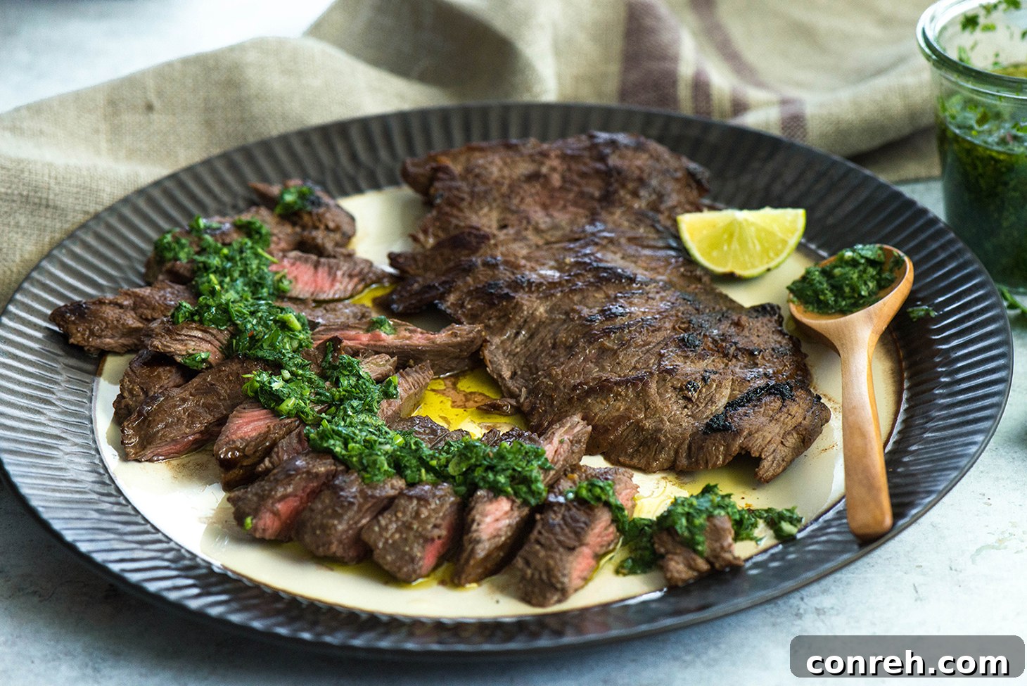 Sliced Churrasco steak with a generous drizzle of green Chimichurri sauce