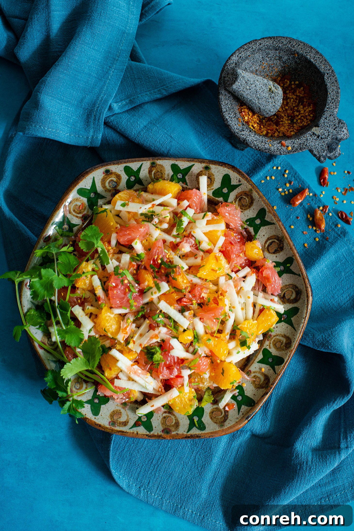 Close-up of Xe'ek salad showcasing the texture of jicama, grapefruit, orange, and chili flakes.