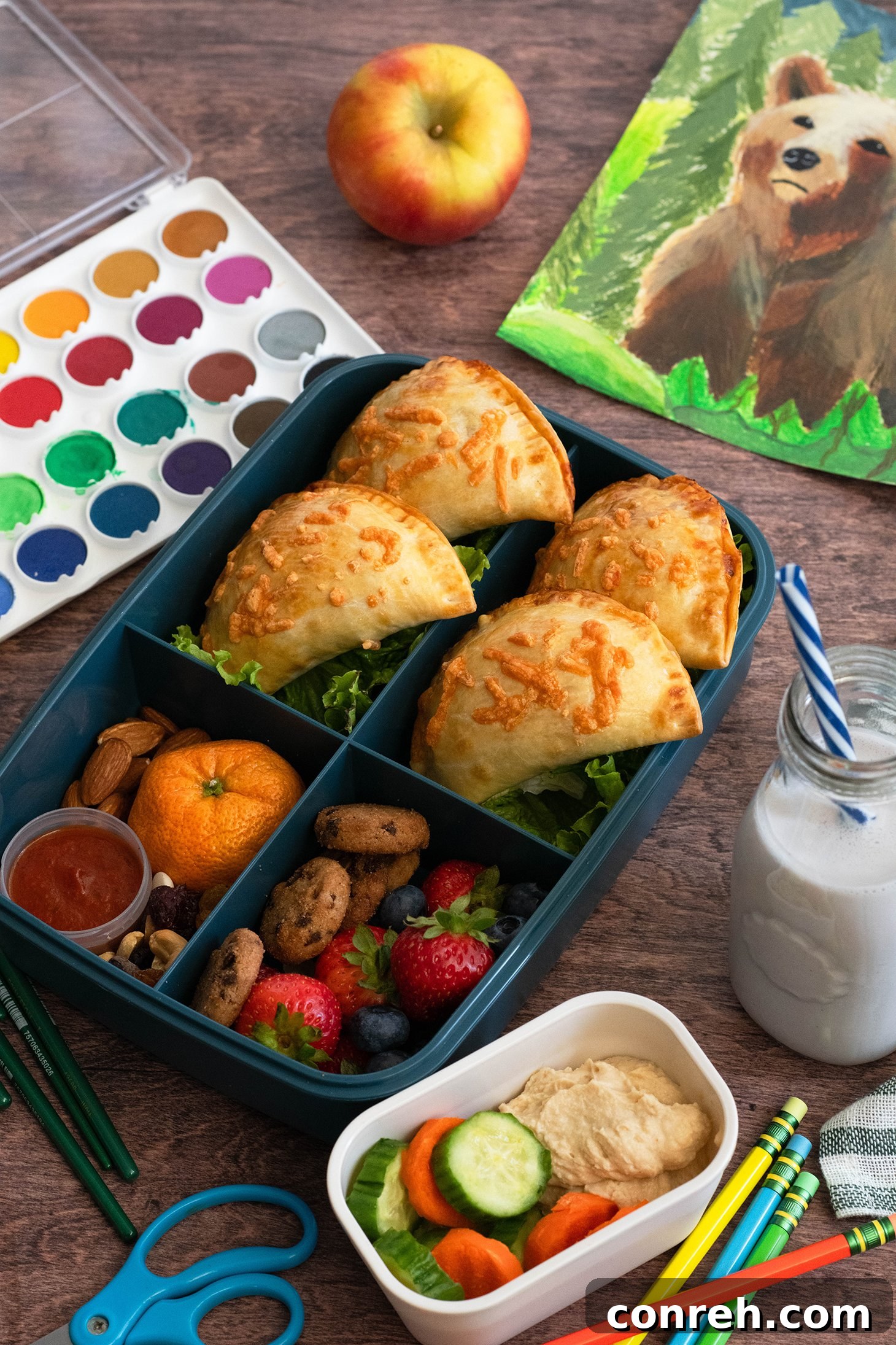 Golden brown Two-Cheese Pizza Empanadas on a baking sheet, ready for lunchboxes.