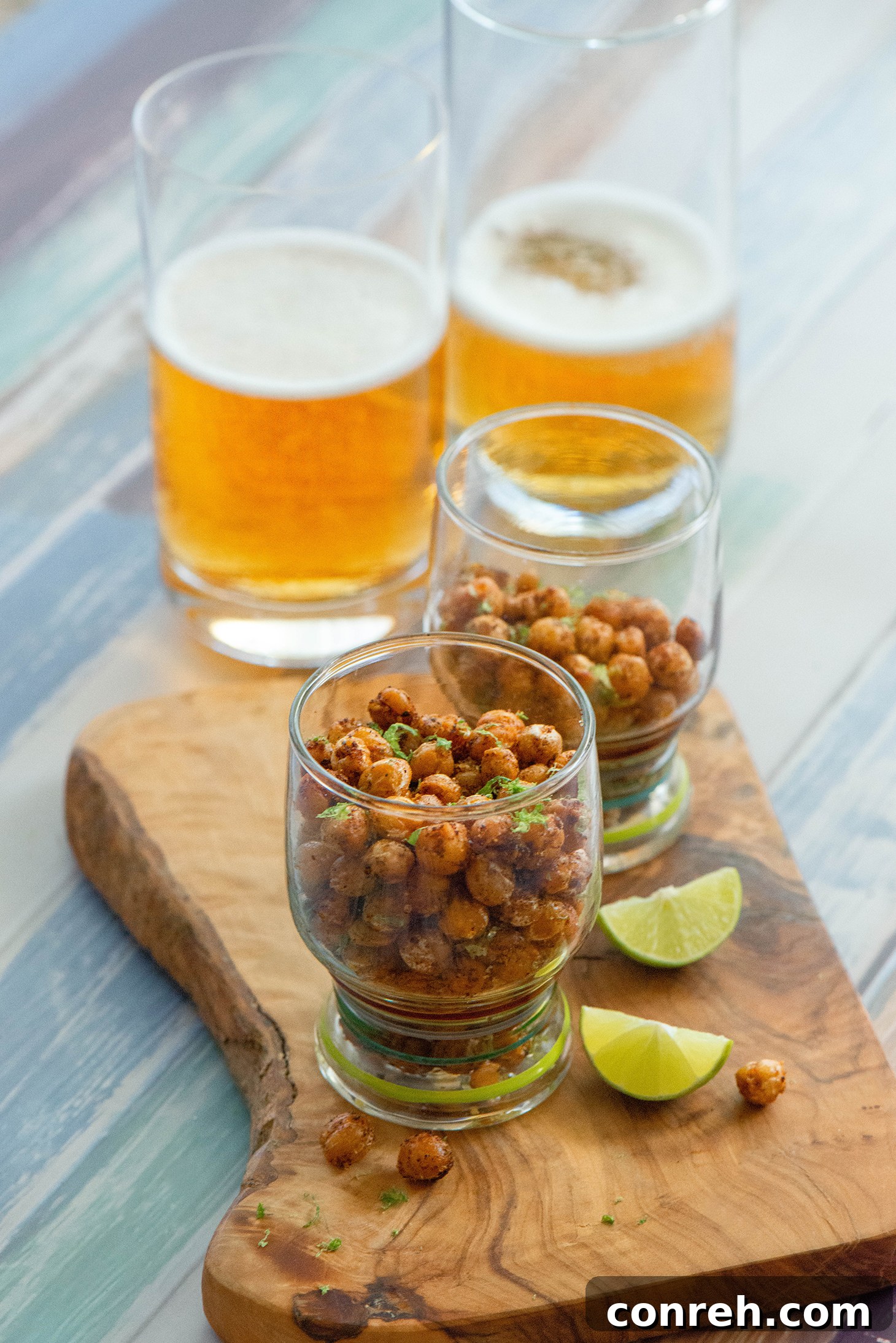 A wider shot of Spicy Garbanzo Beans with fresh lime wedges, ready to be served as a snack.