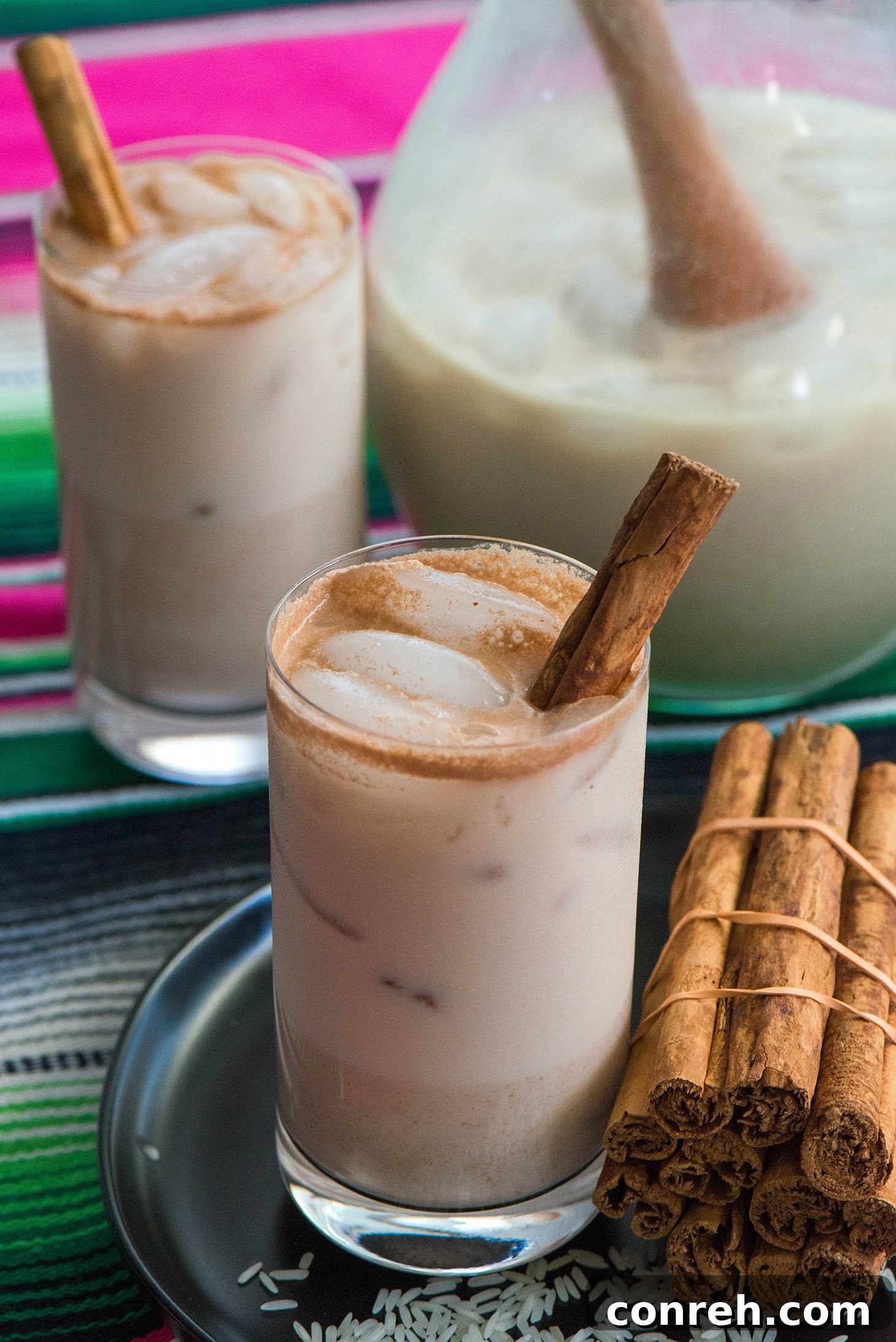 Traditional Mexican Agua Fresca de Horchata in a glass pitcher with cinnamon sticks
