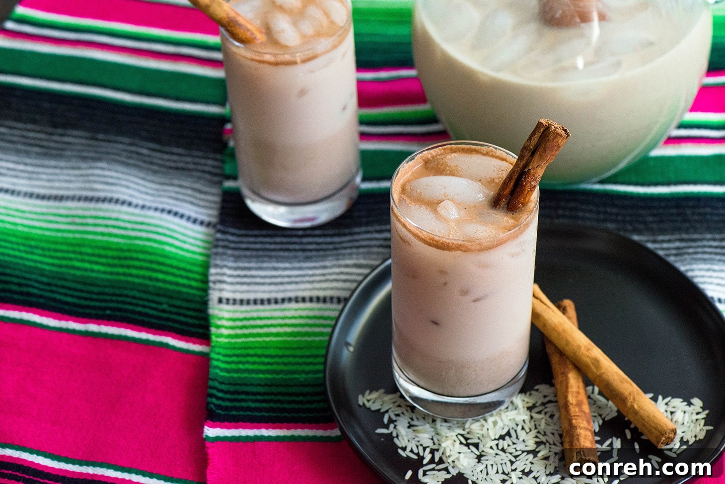 Close-up of a glass of Agua Fresca de Horchata garnished with a cinnamon stick