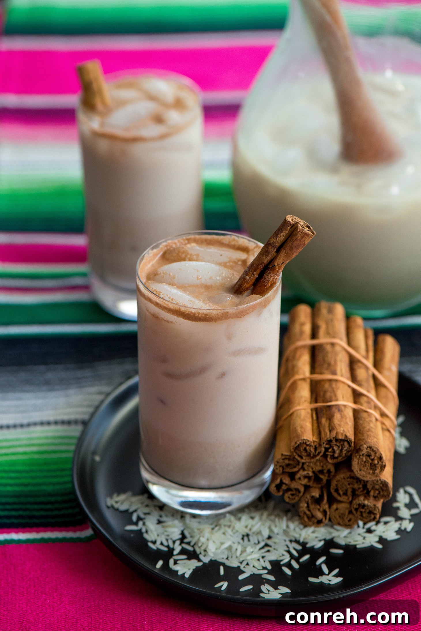 Close-up of fresh Agua Fresca de Horchata in clear glasses with straws and cinnamon sticks