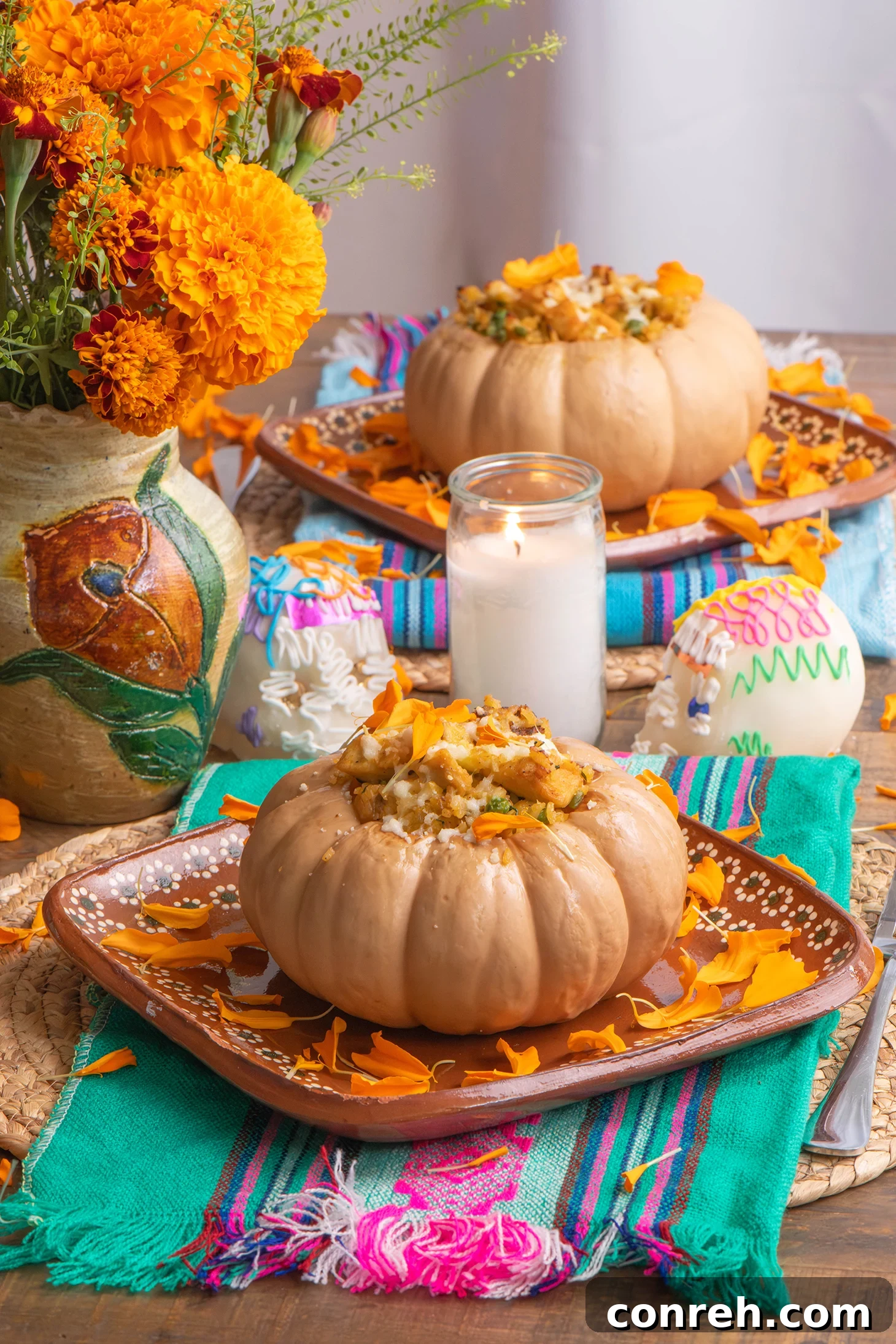 Arroz con Pollo Roasted Pumpkins on a wooden table, garnished with marigolds.