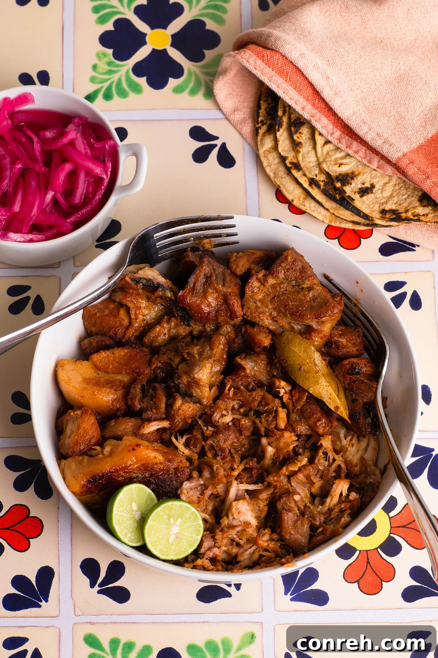 Close-up of golden, crispy carnitas, shredded and ready to serve
