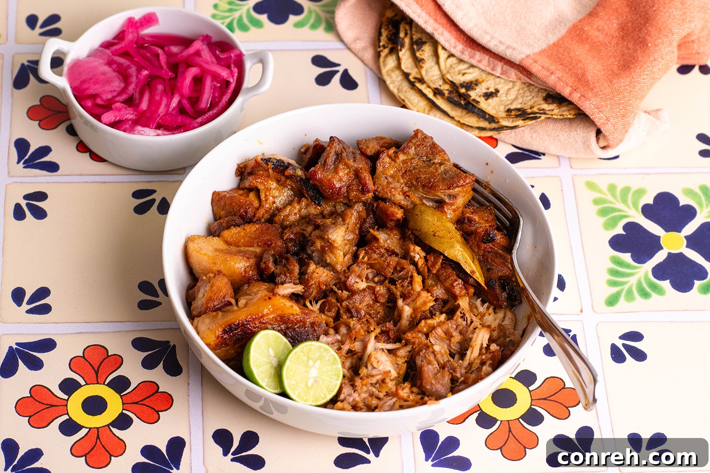 Shredded carnitas with a vibrant garnish of cilantro and onion, ready for tacos
