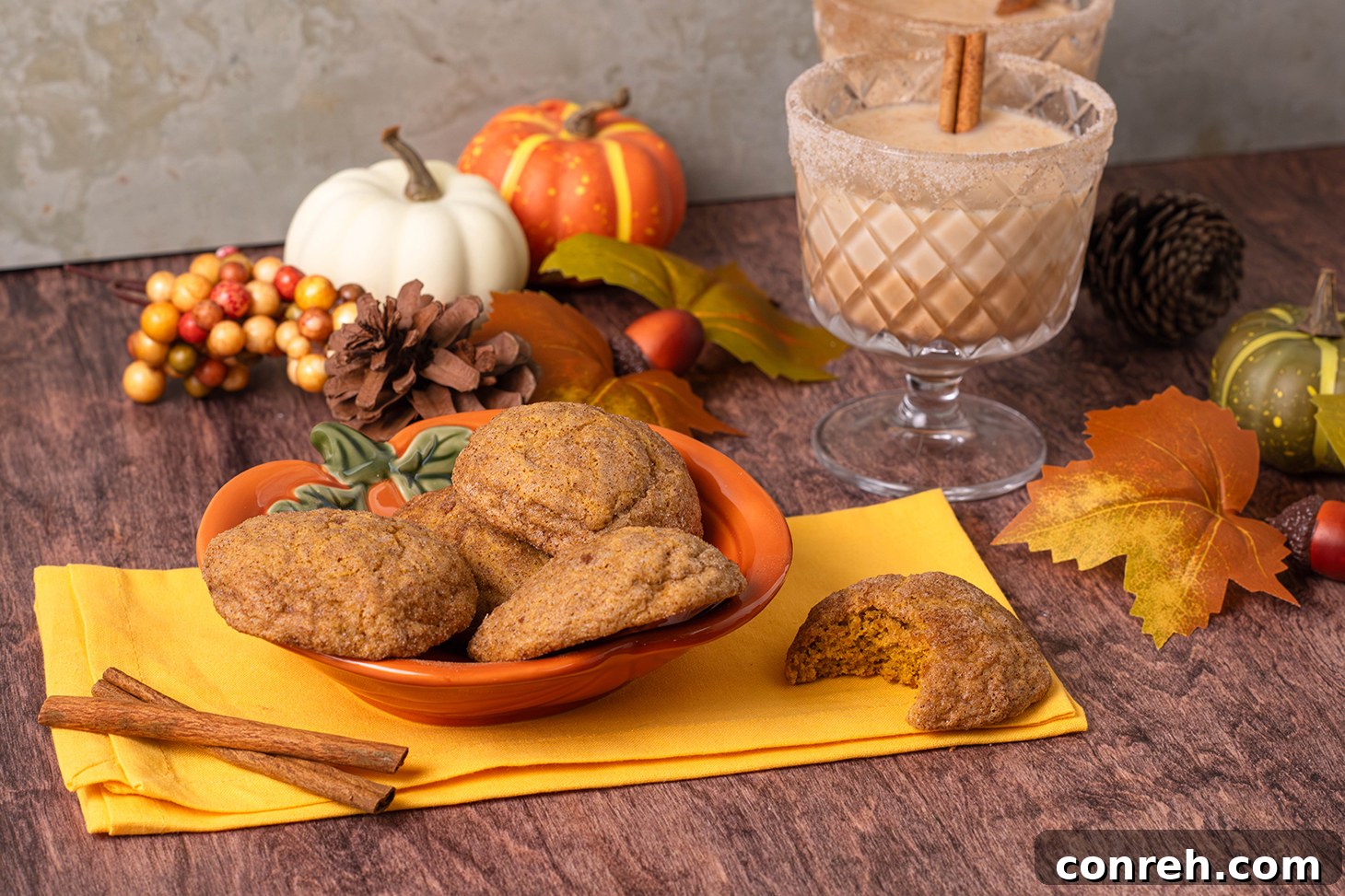 A platter of golden-brown Pumpkin Churro Cookies, perfectly coated in cinnamon sugar, arranged artfully with a few whole spices nearby.