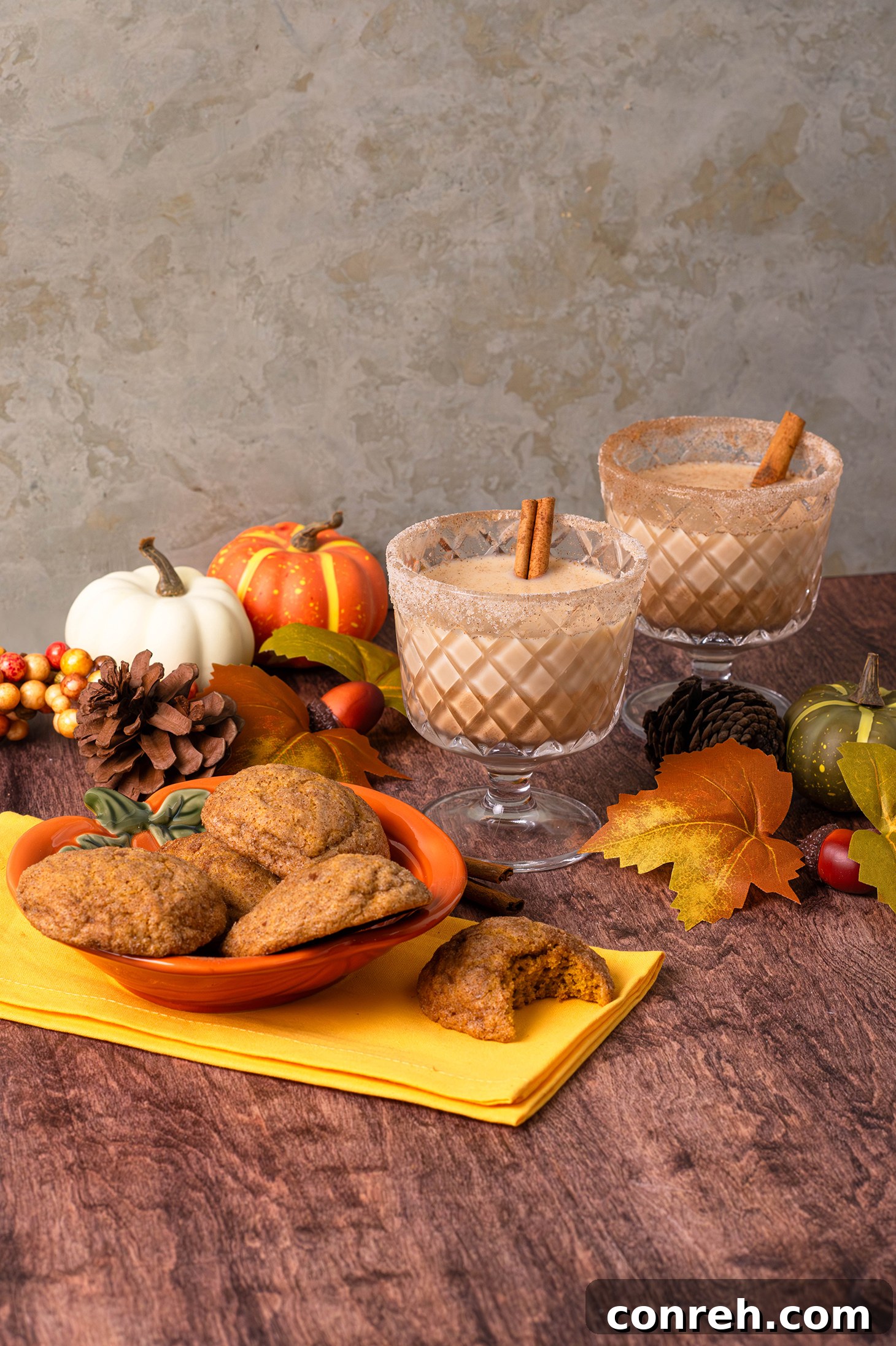 A close-up of a single Pumpkin Churro Cookie with a bite taken out, revealing its soft, tender interior, on a white plate.