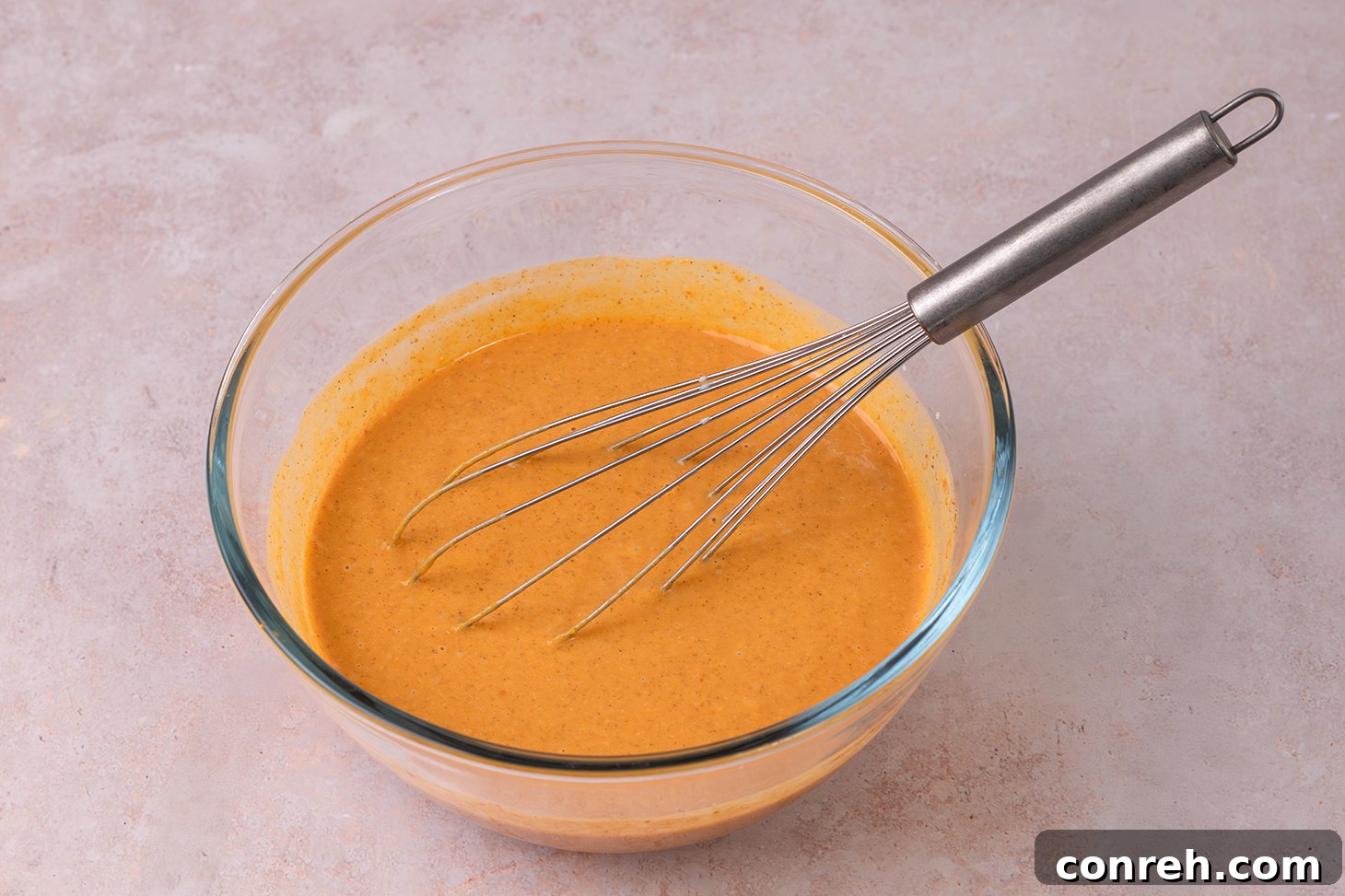 Mixing the pumpkin pie filling in a large bowl with a whisk.